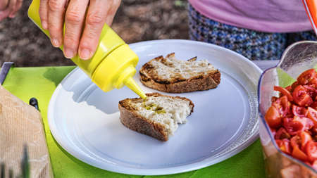 Preparation of the typical Italian bruschetta with toasted bread, garlic and extra-virgin olive oil...