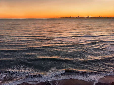 Sunset aerial view of the  on the sea in the golden hour and clouds parade on the horizon