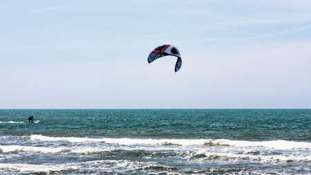 Lido dei Pini, Italy - April 25,2014: On the Roman sea of Lido dei Pini beach athlete performs kitesurfing between waves and foam, a ideal day with rough sea and perfect weather conditions to guaranteed fun.のeditorial素材