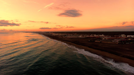 Fantastic and relaxing drone pov at sunset over Rome sea at golden hour with bright mood sky with calm and satin seawater hit by sunbeams.の写真素材