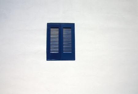 blue window in white wallの写真素材