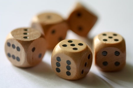 Isolated wooden dice tumbling with black spots