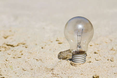 electric lamp bulb on sandの写真素材