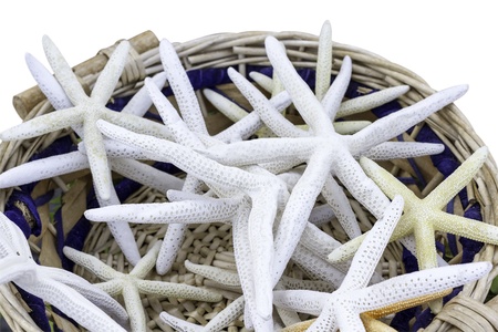 Closeup of braided straw basket full of starfish, isolated on white の写真素材
