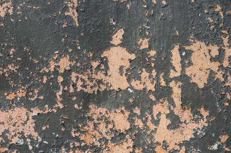 Peeling weathered and aged old faded paint on concrete wall of a house, creating a speckled textureの写真素材