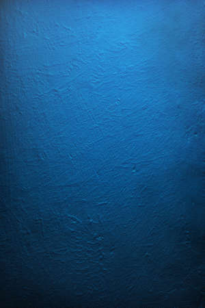 Gradient illuminated deep blue wall, textured.の写真素材