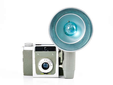 Vintage camera on white background that has a flash accesorie with a blue lightの写真素材