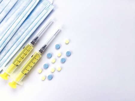 Syringes, medical mask, pills on a white backgroundの写真素材