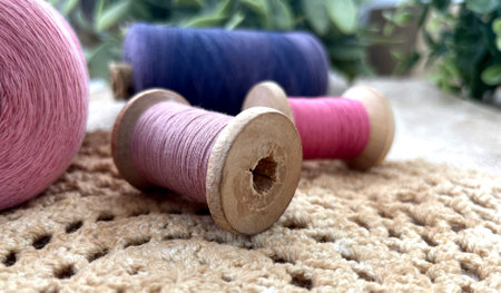 Wooden Old Sewing Reels with pink threads close-up