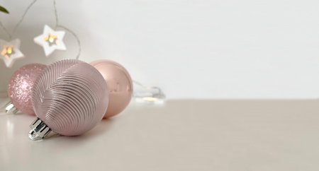 Christmas pink balloons and a garland of white stars on a warm white background.