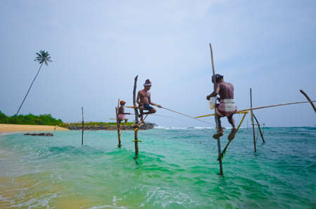 Koggala, Sri Lanka. March 25, 2014 : The local fishermen are fishing in unique style an March 25, 2014 . The standing on the single timber pole and this craft passed down from generation to generationのeditorial素材