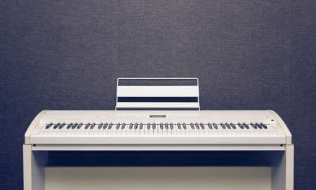 White ivory digital piano over gray wallの写真素材