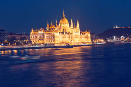 Parliament building of Budapest above Danube river in Hungary at night, neo-gothic style architectureの写真素材