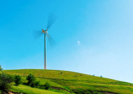 Windmill spinning on green valley, eco green energy conceptの写真素材