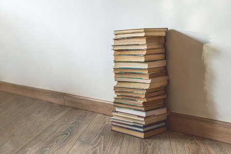 Big stack of old books over white wall, education concept, with copy spaceの写真素材