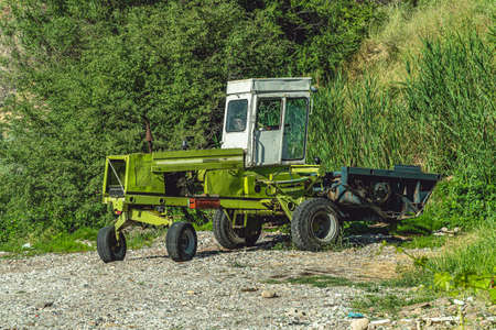 Old funny design green tractor parked on country roadside