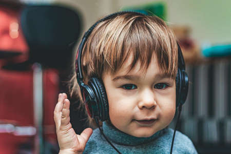 Portrait of small child or toddler in headphones listening to music, close up, selective focusの写真素材