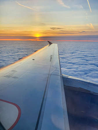 Beautiful sunset sky view through airliner porthole, mobile photoの写真素材