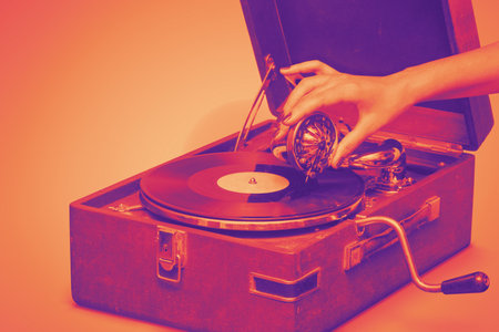 A vintage gramophone, bathed in warm hues, its needle gently placed on a vinyl record by a delicate...