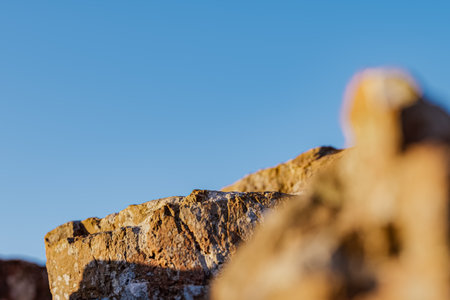 3d presentation pedestal or dais made of rock illuminated by sunlight. 3d rendering of mockup of...