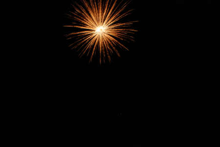 A single golden firework, on the top of the image, very well focuses