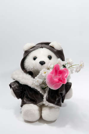 Teddy bear with bunch of flowers isolated on the whiteの写真素材