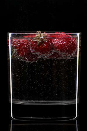 Cocktail with strawberries isolated on blackの写真素材