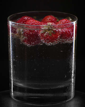 Cocktail with strawberries isolated on blackの写真素材