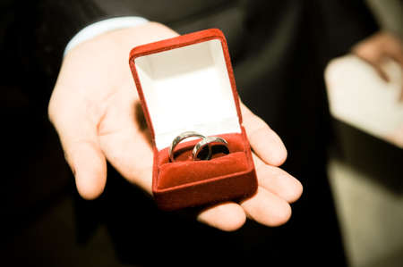 Man in suit holding engagement ring