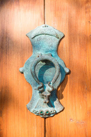 Door knocker in the shape of a bull on old wood doorの写真素材