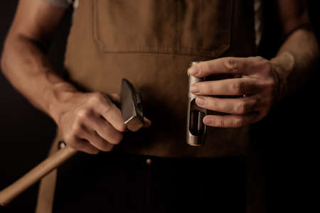 Hands holding leather craft object with tool using for manufactureの写真素材