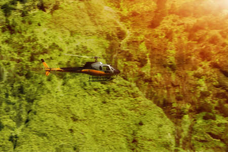 Rescue helicopter over the trees in the mountainsの写真素材