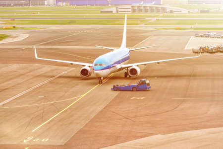 Airplane ready for take-off in a airport hub. Commercial passenger airplane during push back...