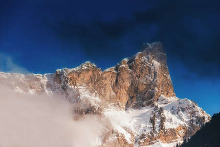 Top of High mountains, covered by snow. Winter mountains on a bright sunny day. Alps mountain landscape with cloudy sky.の写真素材
