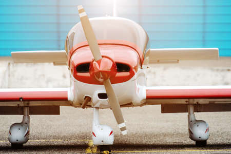 Propeller plane parking at the airport. Sunny day. In front of hangar.