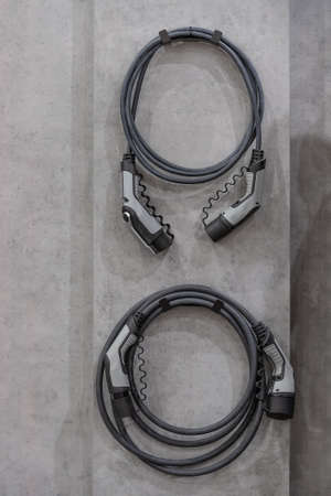 Electric car concept - electric car charging plug. Mounted on concrete wall.