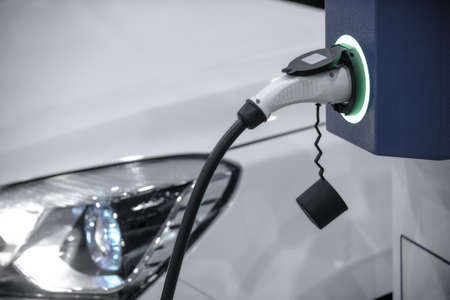 EV Car or Electric car at charging station with the power cable supply plugged in. Eco-friendly alternative energy conceptの写真素材
