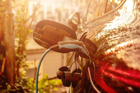 Electric charge station for electric car with charger to recharge electricity into vehicle on city street, modern eco infrastructure.の写真素材
