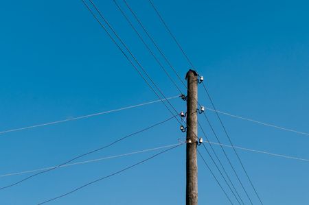 Electric wires are stretched every which way from a column