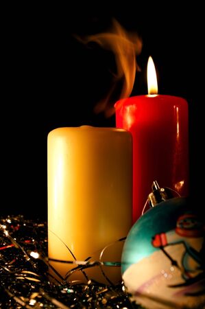 Two candles and New Year's sphere on a black backgroundの写真素材