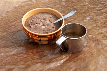 The clay bowl and iron mug with sand cost in waterの写真素材