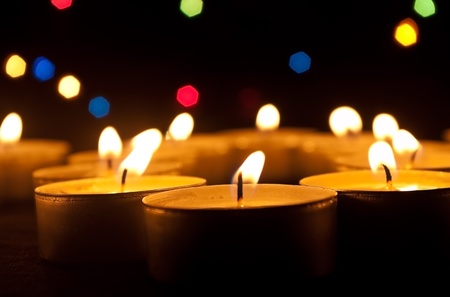 Tea candles burn on an abstract dark backgroundの写真素材