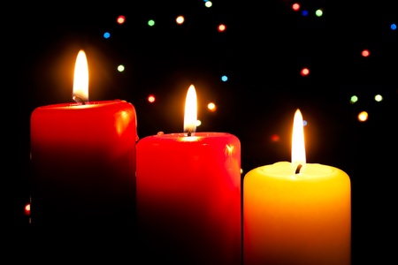 Three burning candles on a dark abstract backgroundの写真素材