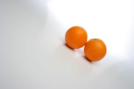 A pair of juicy oranges, side by side over a white background, big space for text and design elements. Look at my gallery for more fruits and vegetablesの写真素材