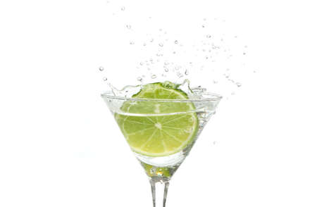 Green lime splashing into a martini glassの写真素材