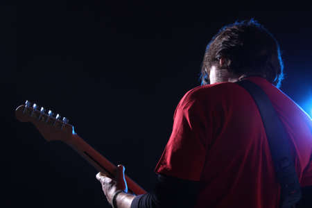 Musician playing electric guitar on stageの写真素材