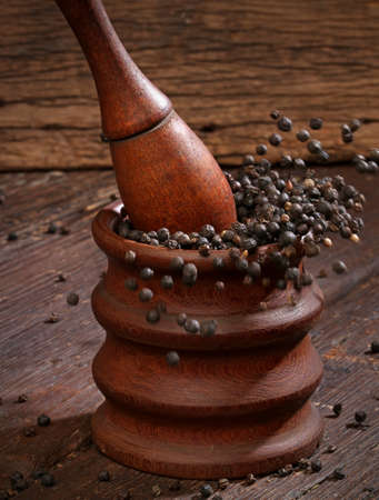 Grinding black pepper with a mortar and pestle の写真素材