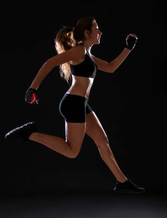 Fitness. Young woman doing exerciseover black background
