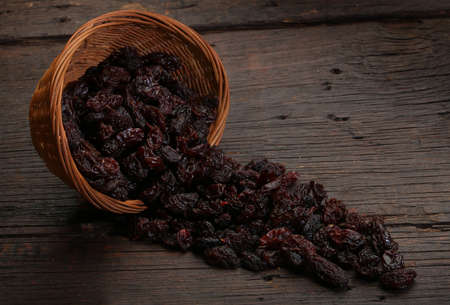 Group of raisins in a bowl, over a wooden backgroundの写真素材