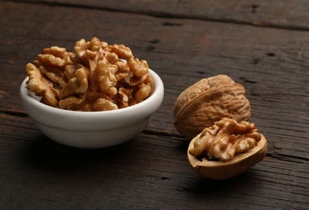 Group of delicious nuts in a bowl, over a wooden background